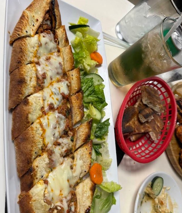Turkish pide, a long flatbread topped with melted cheese, served with salad.